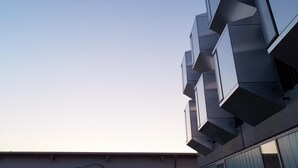 Un edificio moderno con un diseño arquitectónico único y balcones salientes.