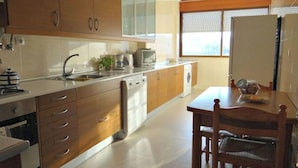 Eine moderne Küche mit Holzausstattung, einem Geschirrspüler, einer Mikrowelle und einem Essbereich mit Tisch und Stühlen.