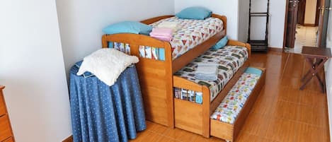 A room with a bunk bed, a small table, and a chair.