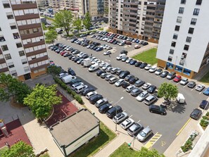 Un parking à plusieurs étages, avec de nombreuses voitures garées et quelques piétons.