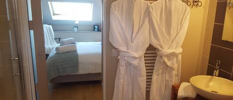 A hotel bathroom with a sink, mirror, and towel rack.