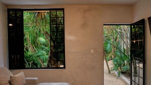 Una habitación con un ventanal grande, un sofá y suelo de hormigón.