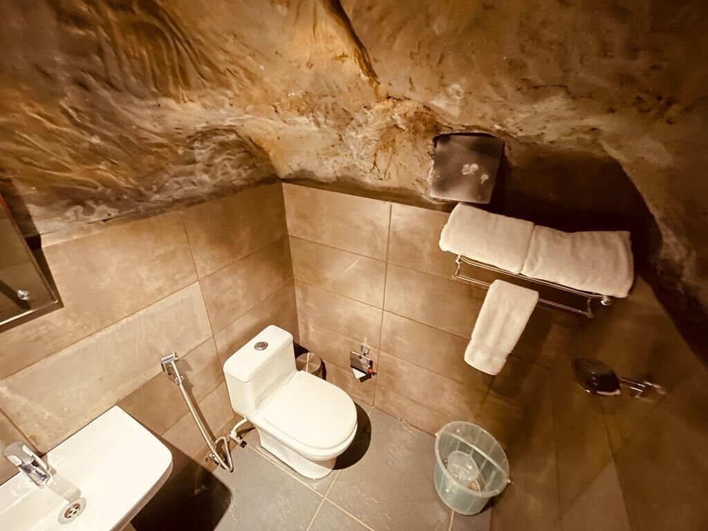 Une salle de bain équipée de toilettes, d’un lavabo et d’un porte-serviettes.