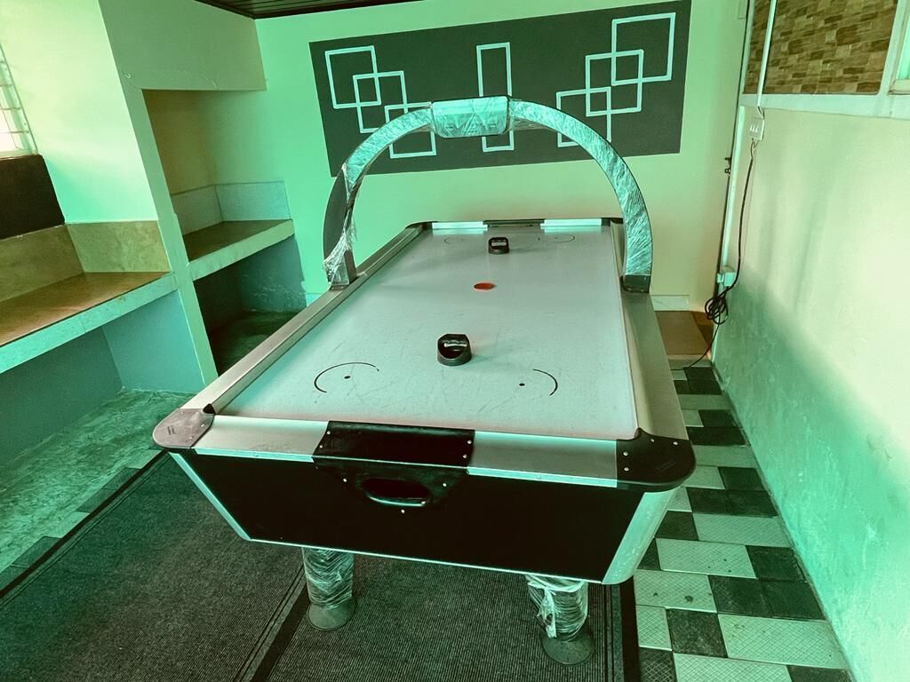 A pool table with a geometric wall design in the background.