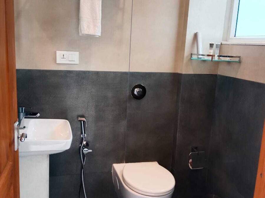 A compact bathroom with a toilet, sink, and shower.