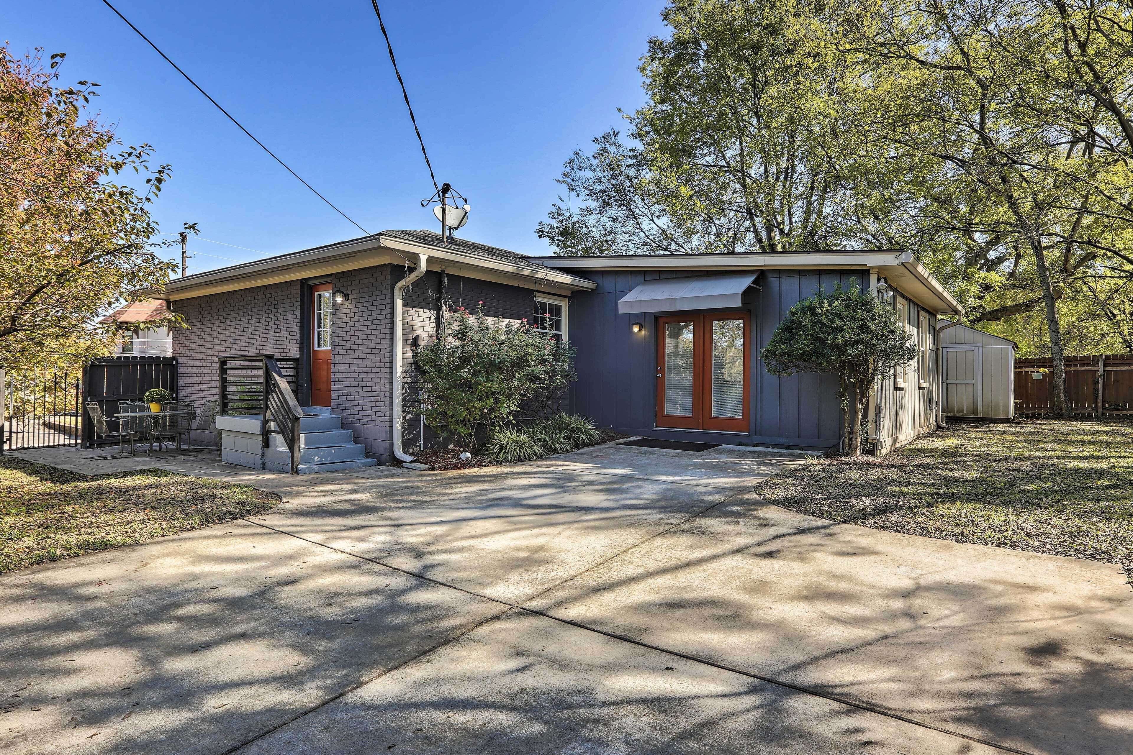 Une maison à deux étages avec un porche à l’avant, un petit garage attenant et une pelouse bien entretenue.