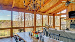 Un comedor de madera con una mesa grande, sillas y vistas al exterior.