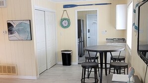 A spacious living area with a dining table, chairs, a coffee table, and a TV stand. - Water Views, Pool, Private boat dock, Walking distance to Times Square (Fort Myers Beach)