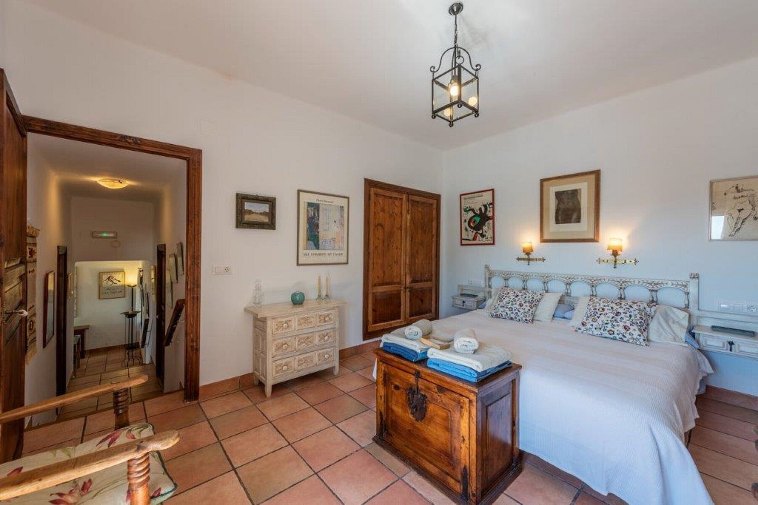 A bedroom with a bed, dresser, chest of drawers, and a mirror.