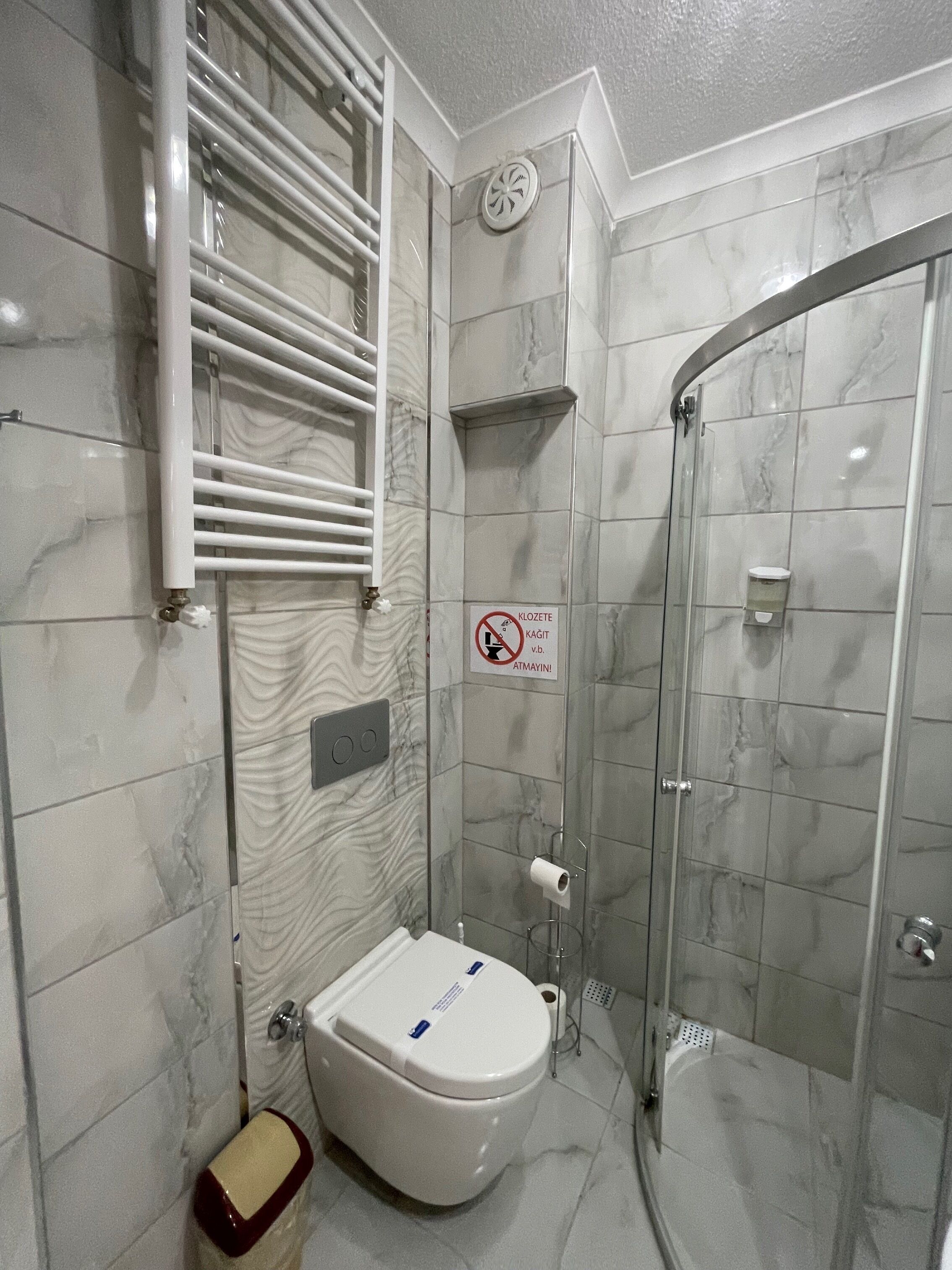 Un baño moderno con ducha, inodoro y toallero.