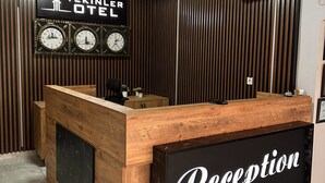 A reception desk with a sign that reads "Reception" and a wall clock above it. - Tekinler Otel (Balikesir)