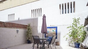 An outdoor patio with a table and chairs, a potted plant, and a tiled floor. - 1-Bedroom Flat with Terrace, near Metro and Arena (Loures)