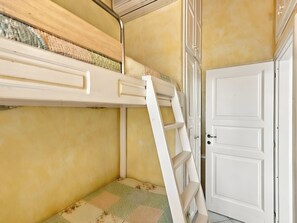 A room with a bunk bed, a door, and a patterned rug. - Vacation home Dalila by Interhome (Porto Istana)