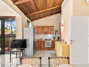 A compact kitchen with wooden cabinets, a built-in oven, and a refrigerator.