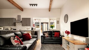 A modern kitchen with grey cabinets, a black countertop, and a built-in stove. - Webbington Farm Holiday Cottages (Axbridge)