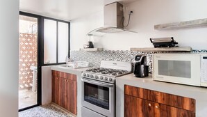 Una cocina moderna equipada con estufa a gas, horno, microondas y cafetera.