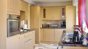 Une cuisine moderne avec des meubles en bois, des appareils électroménagers en acier inoxydable et un plan de travail en granit.