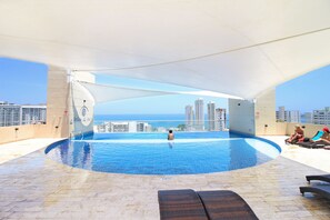 Une piscine intérieure offrant une vue sur la mer et les immeubles de grande hauteur.