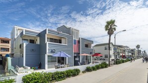 A beachfront hotel with a patio area, outdoor seating, and a view of the beach. - Remodeled Beachfront Mission Beach Condo on the boardwalk with Amazing Views! (San Diego)