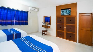 Een hotelkamer met twee bedden, een televisie, een kledingkast en een klein tafeltje.
