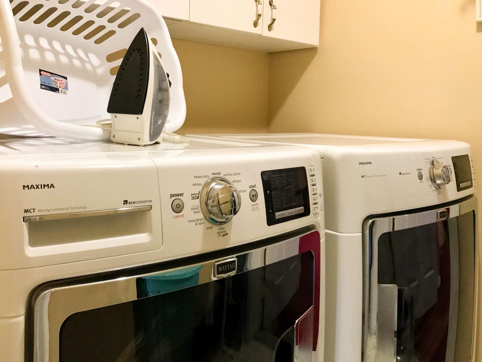 Deux lave-linge Maytag MAXIMA à chargement frontal, dotés d’un panneau de commande, d’un bouton d’alimentation et d’un écran numérique.