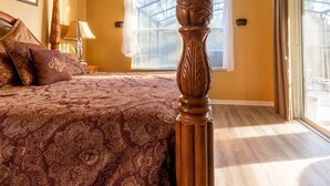 Une chambre à coucher avec un lit à baldaquin, une fenêtre avec des stores et une vue sur l’extérieur.