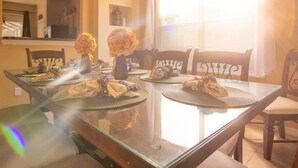 Une table à manger avec des sets de table, des chaises et des centres de table floraux.