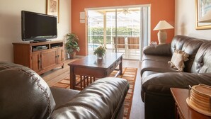 A living room with a television, leather sofa, and a dining area with a table and chairs. - 3 Bed 156 (Davenport)