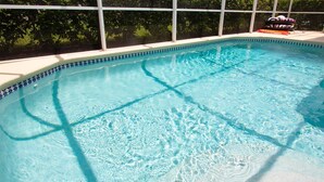 A clear swimming pool with a tiled edge and a view of greenery in the background. - 3 Bed 156 (Davenport)