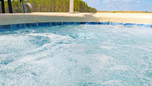 A hot tub with visible bubbles and a tiled edge. - 4 Bed 428 (Davenport)