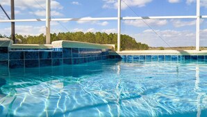 A clear indoor swimming pool with tiled walls and a view of trees in the background. - 4 Bed 428 (Davenport)