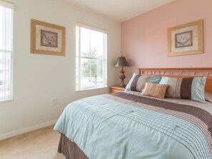 A bedroom with a large bed, two bedside tables, a window, and two framed pictures on the wall. - 5 Bed 388 (Davenport)