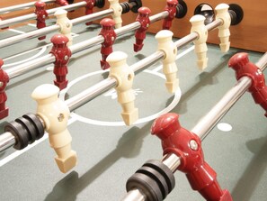 Ein Detailbild eines Kicker-Tischs mit roten und weißen Spielfiguren und Stangen.