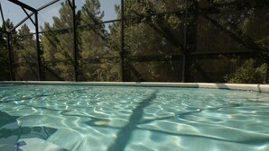A clear indoor swimming pool with a view of trees through a glass enclosure. - 4 Bed 231 (Davenport)