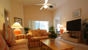A living room with a sofa set, a coffee table, a TV, and a ceiling fan. - 4 Bed 231 (Davenport)