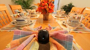 A dining table set with plates, glasses, and a vase of flowers. - 4 Bed 231 (Davenport)