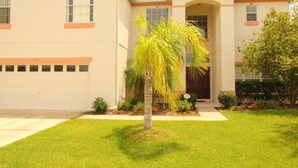 A two-story house with a garage, a front door, and a well-maintained lawn. - 6 Bed 2525 (Kissimmee)