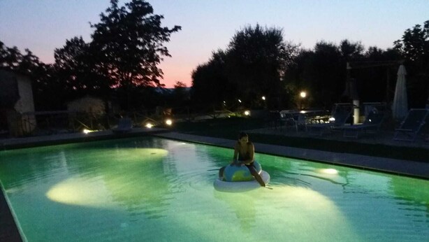 Une piscine avec une personne sur un toboggan aquatique.