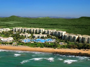 Ein Resort mit mehreren Gebäuden, einem Pool und einem Strand.