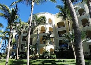 Ein mehrstöckiges Hotel mit Balkonen und Palmen.