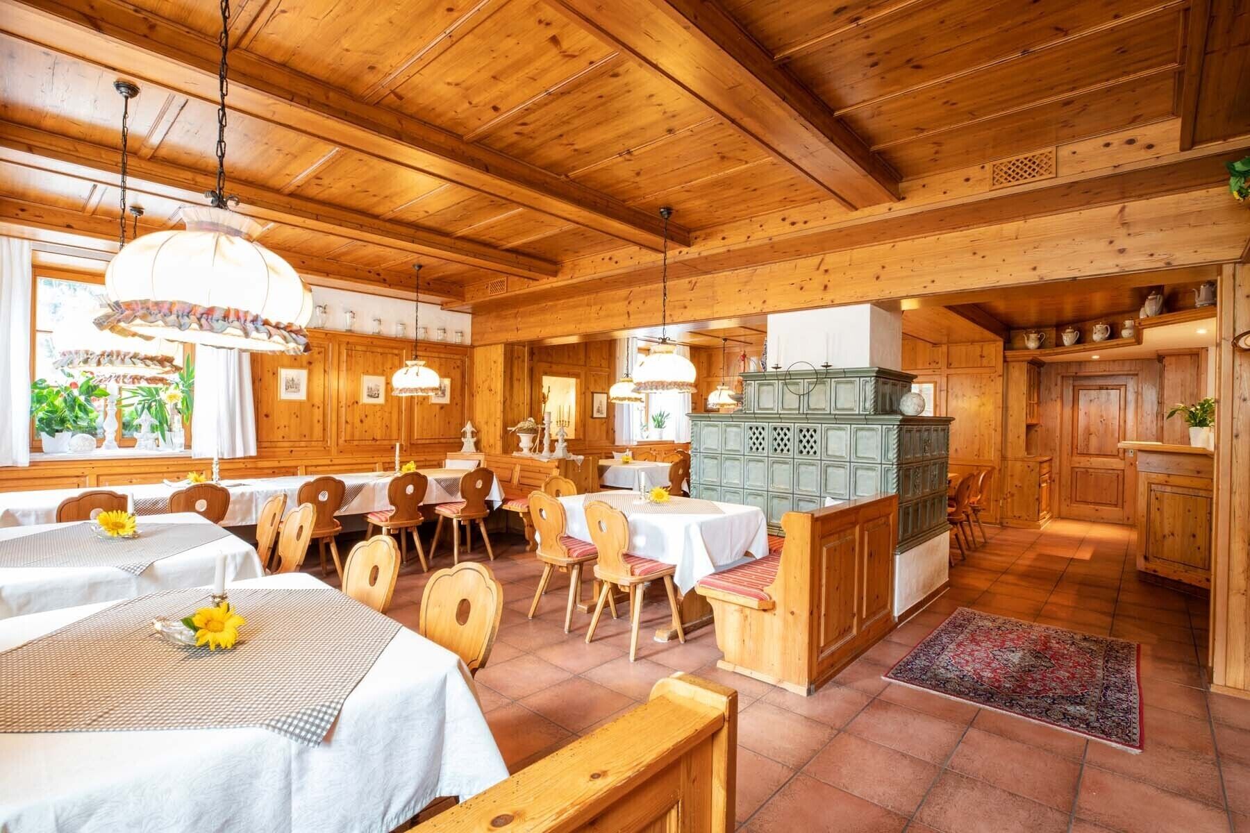 Ein Holzinnenraum mit Tischen und Stühlen, einer Küchenzeile und einem Esszimmer.