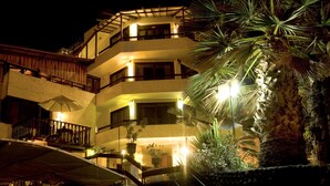 A multi-story hotel with outdoor staircases, balconies, and potted plants.