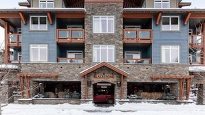 A multi-story hotel with a stone facade, multiple balconies, and a central entrance labeled "Blackstone." - Mountain Luxe (Canmore)