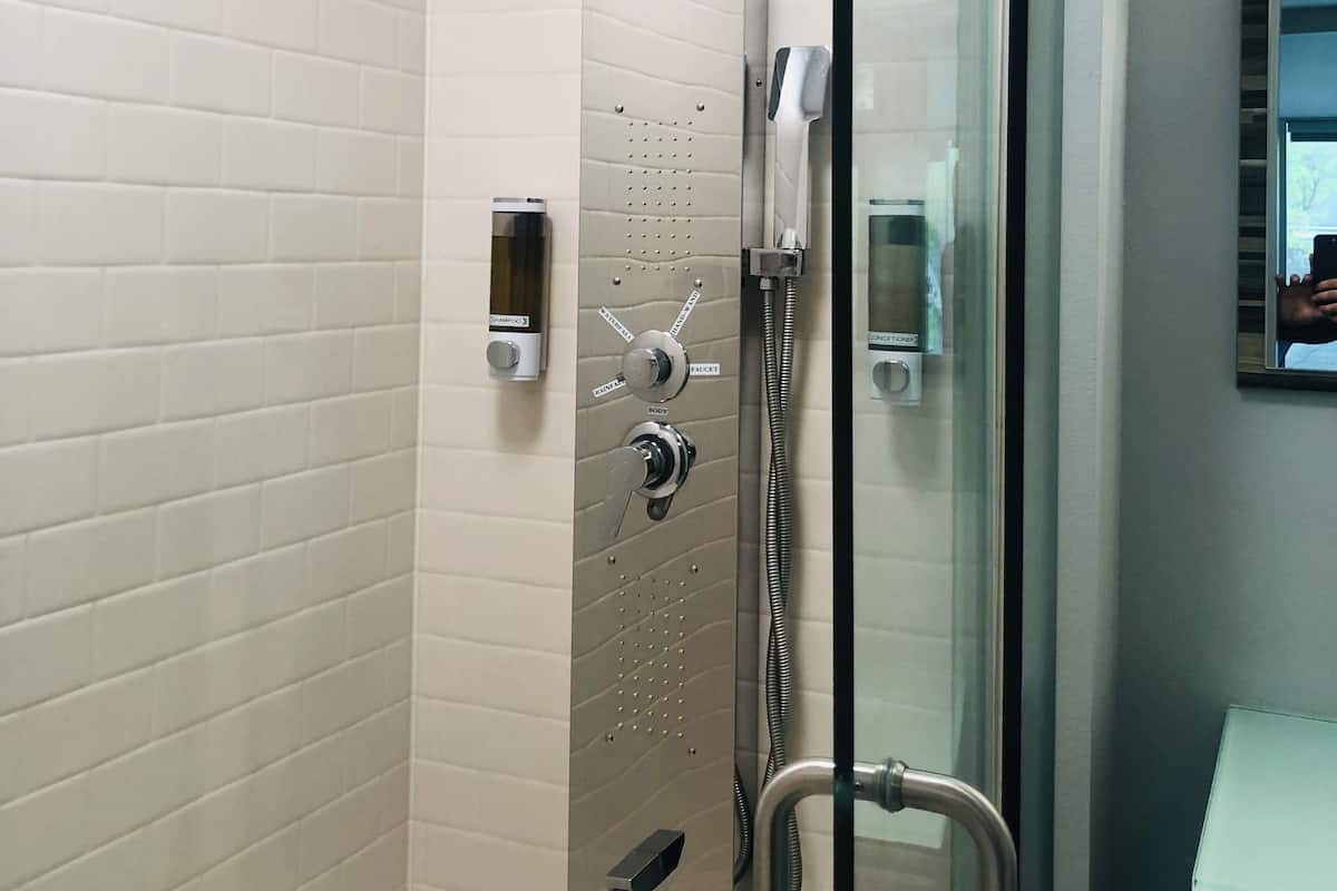 luxurious deluxe king room w/ 65'' tv - complimentary drinks - non-smoking | bathroom | shower, hydromassage showerhead, designer toiletries, hair dryer