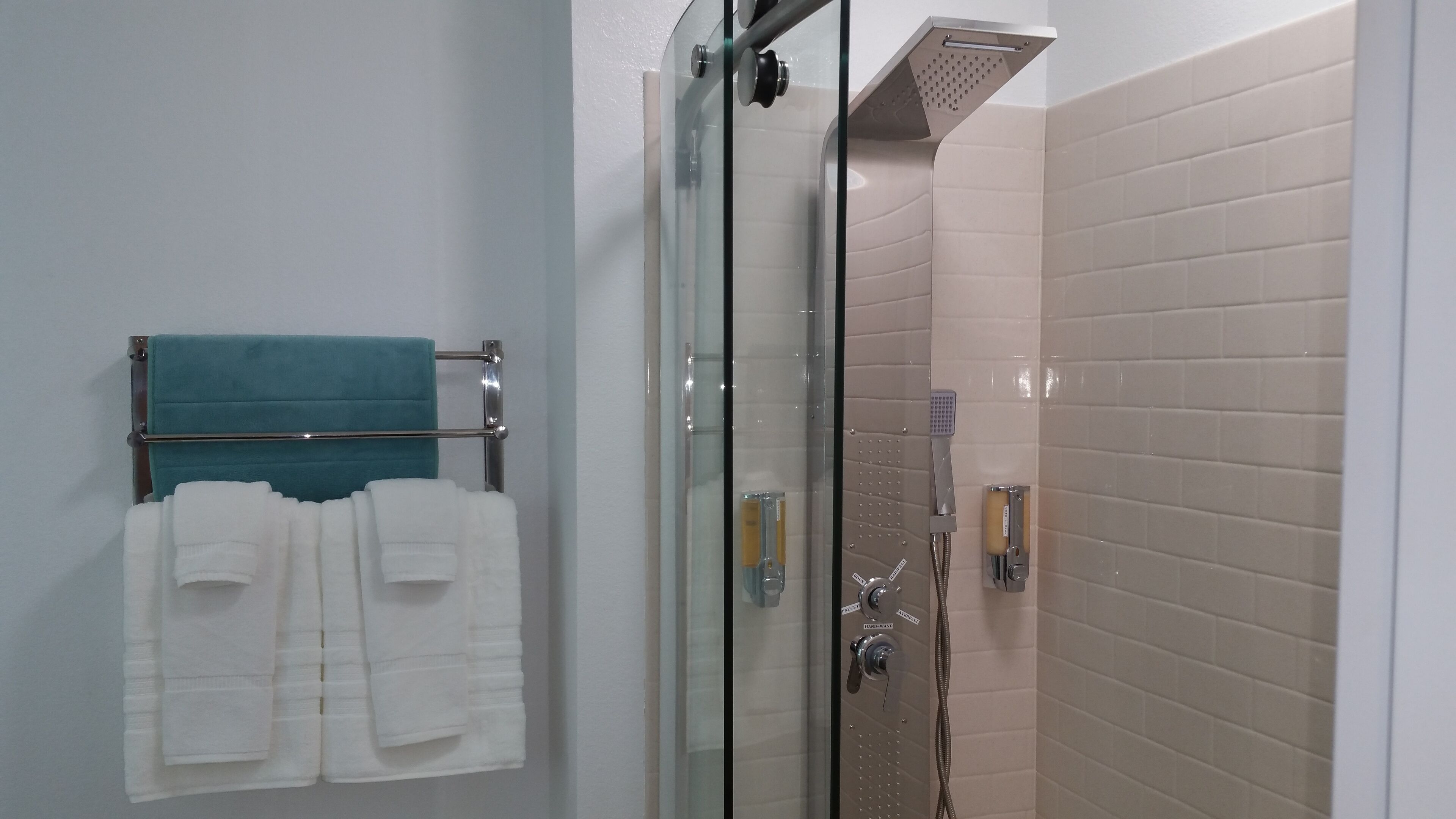 luxury suite - bedroom w/ king bed and 65'' tv and livingroom with sofa queen bed and another 65' tv | bathroom | shower, hydromassage showerhead, designer toiletries, hair dryer