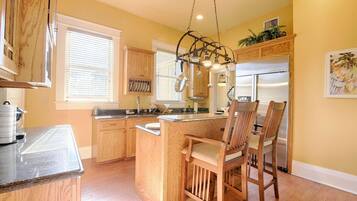 A kitchen with wooden cabinets, a central island, and a hanging light fixture.