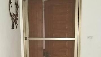 Una puerta de madera con un panel de vidrio y un picaporte de metal.