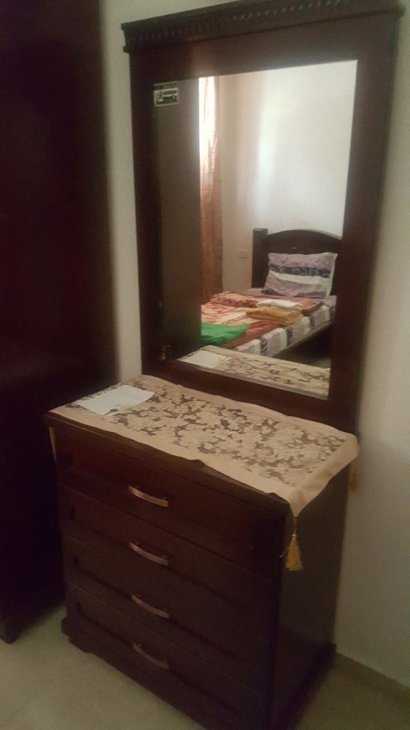 A wooden dresser with drawers and a mirror above it.