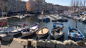A marina with various boats docked, buildings in the background, and a clear sky. - Atmospheric villa with nice sea view in a quiet green area (La Croix-Valmer)