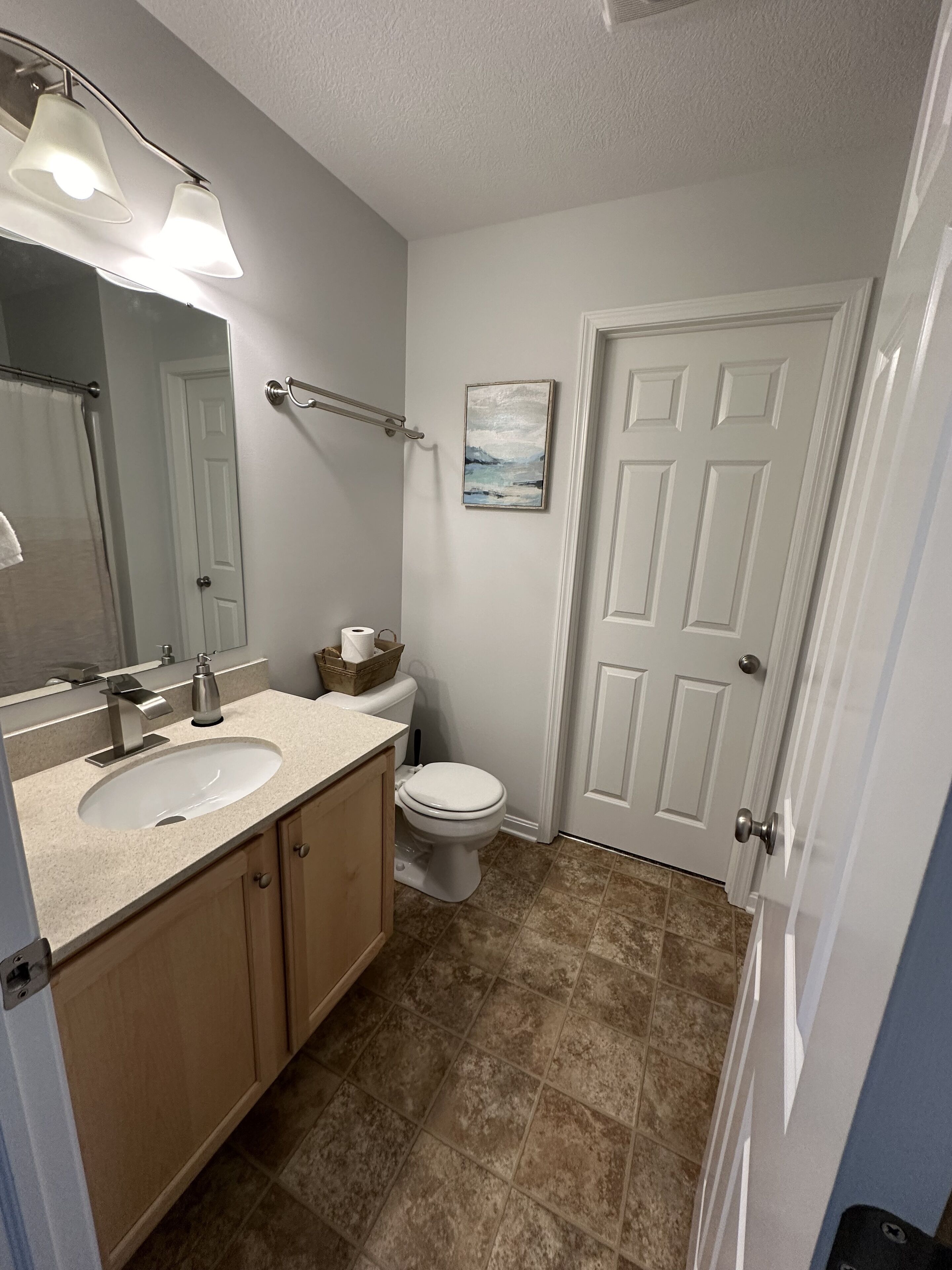 Une salle de bain avec deux lavabos, des toilettes et un rideau de douche.
